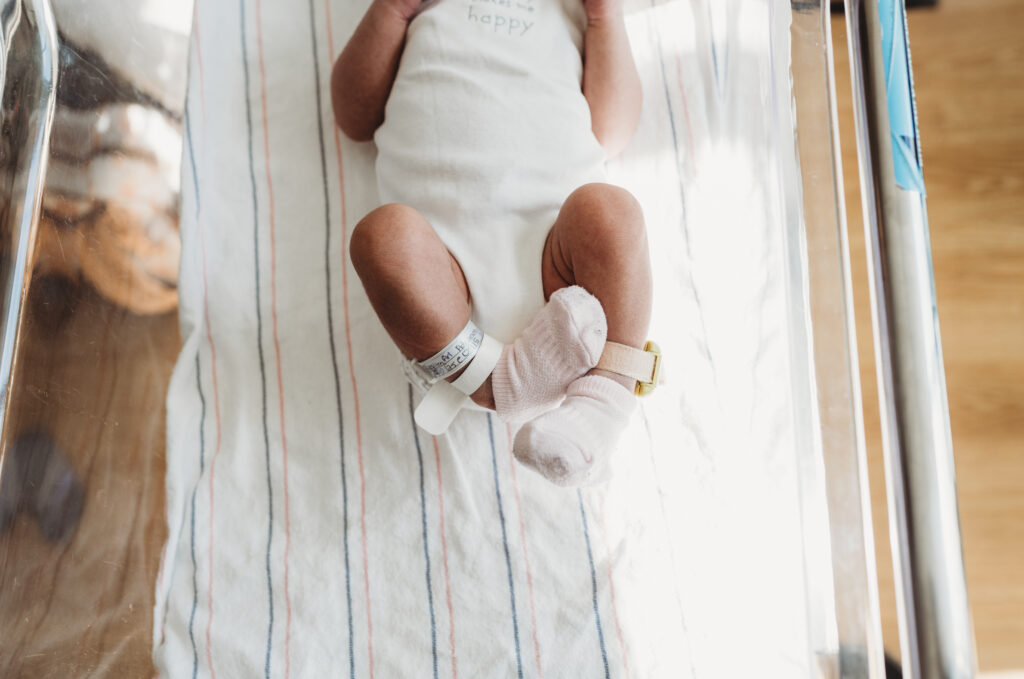 newborn baby feet while laying in bassinet at hospital after birth 
fresh 48 photography