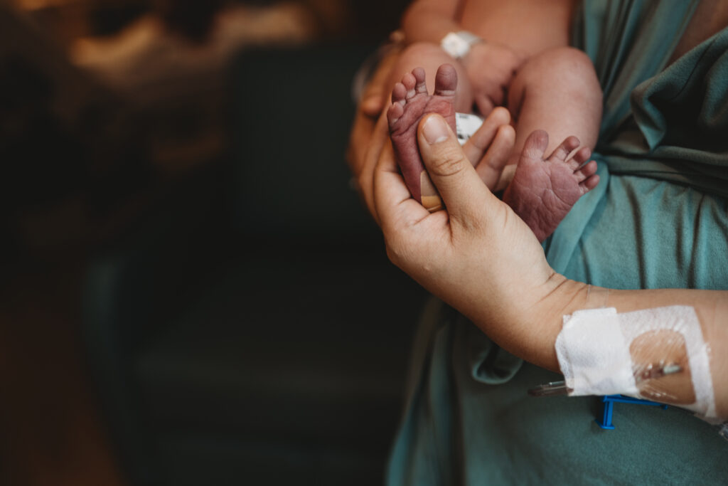 mother holding newborn baby feet 
fresh 48 photography