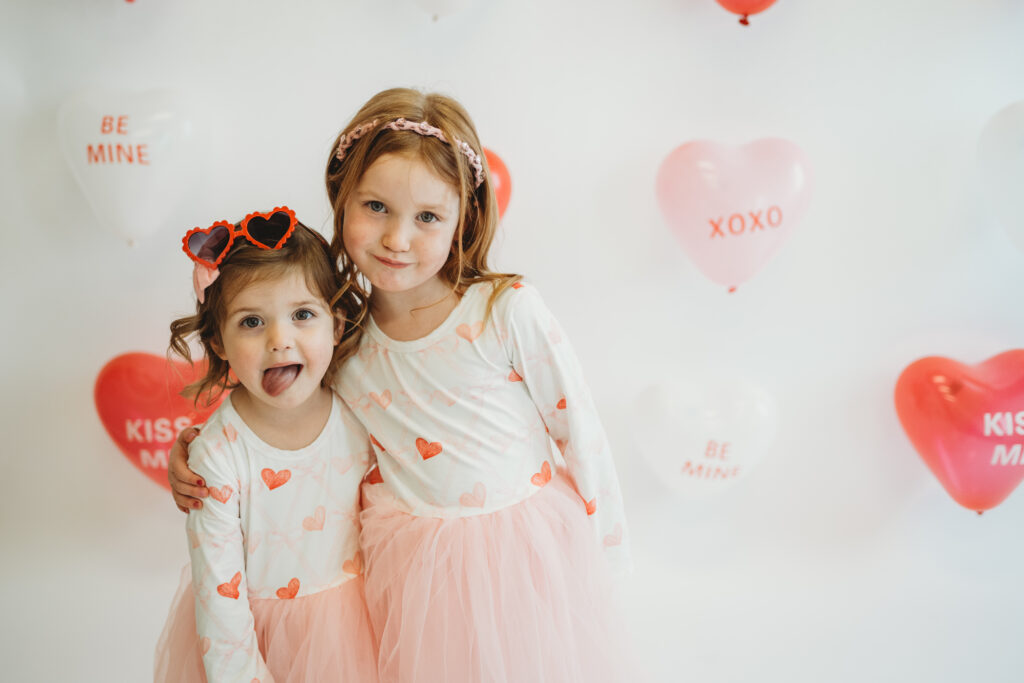Children celebrating Valentine’s Day with balloons and confetti during family photo session