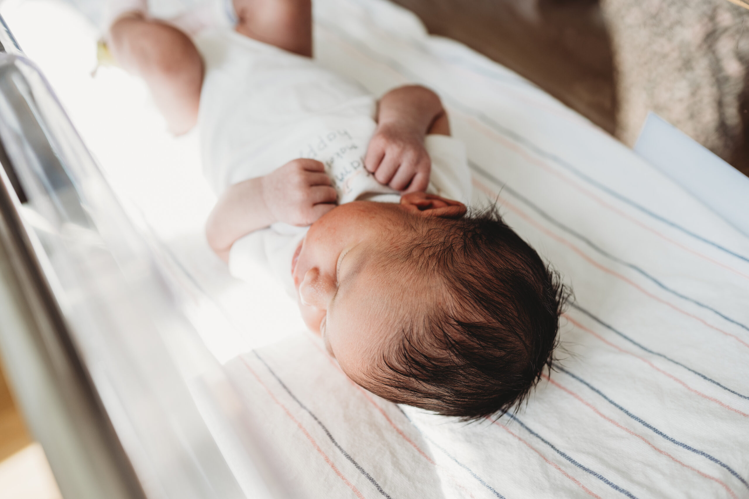 Newborn baby girl sleeping peacefully in hospital bassinet during Fresh 48 photos