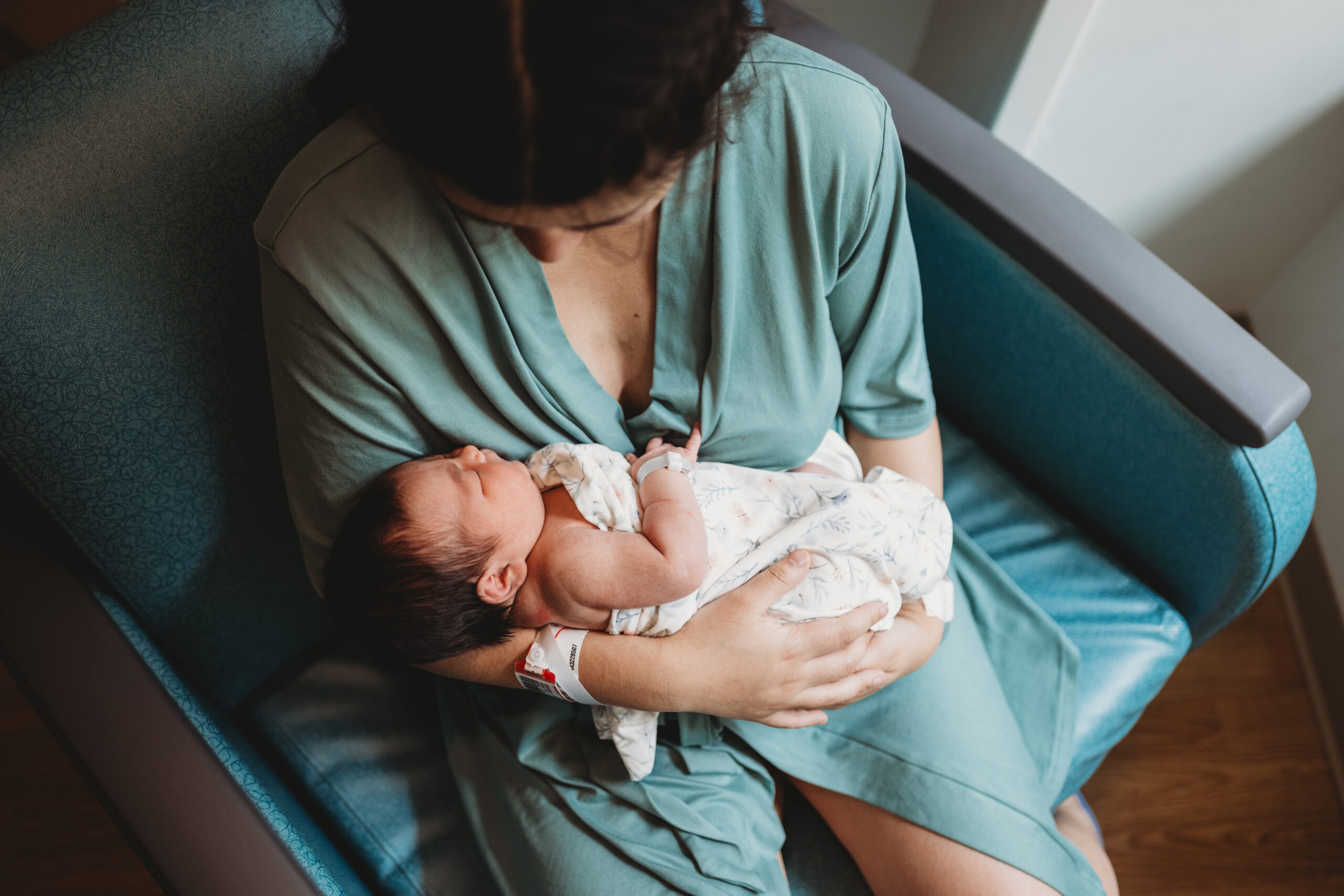 Mother gazing lovingly at her newborn daughter during a hospital photo session