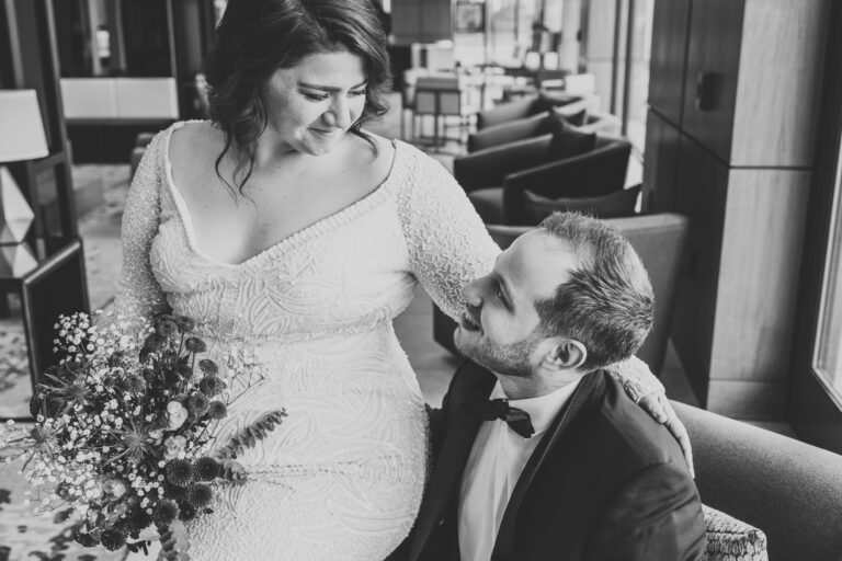 black and white photo of bride and groom on wedding day sitting together
