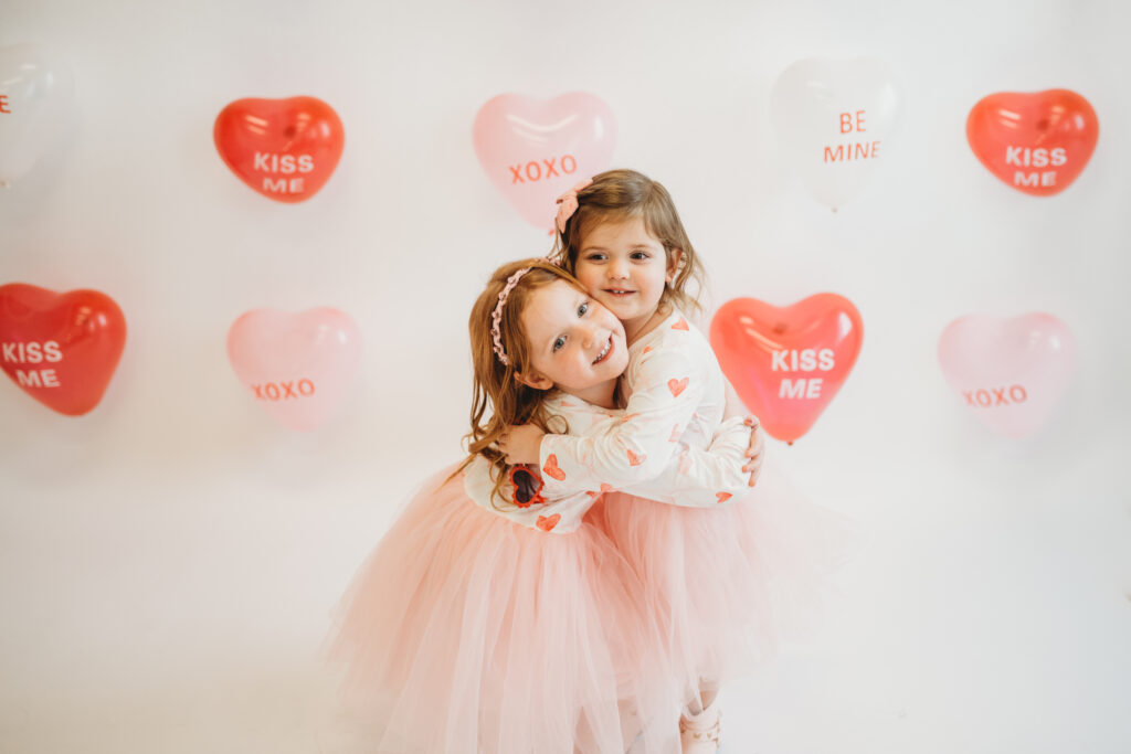 Children celebrating Valentine’s Day with balloons and confetti during family photo session