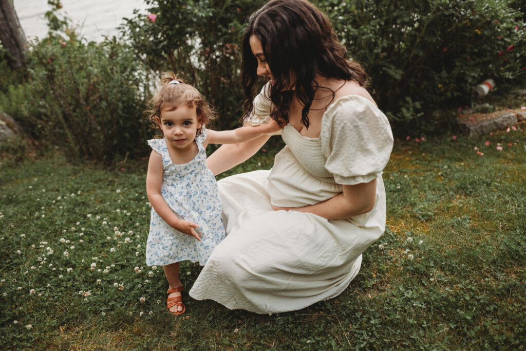 Blue Hill maternity photographer capturing family along wooded path by cottage